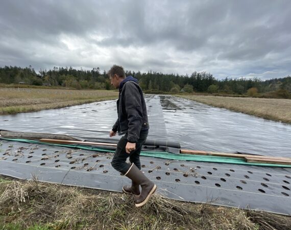 Eric, co-owner of NW Meadowscapes, walks across his farm